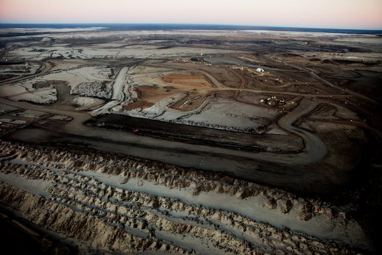 A view over dark tar sands to the horizon