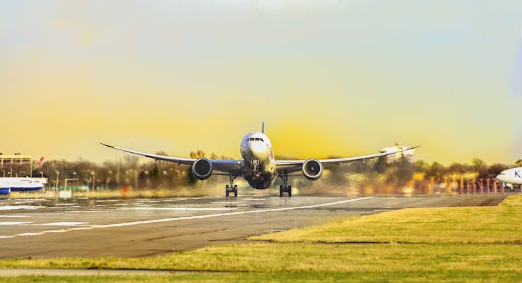 A commercial plane lands on a runway