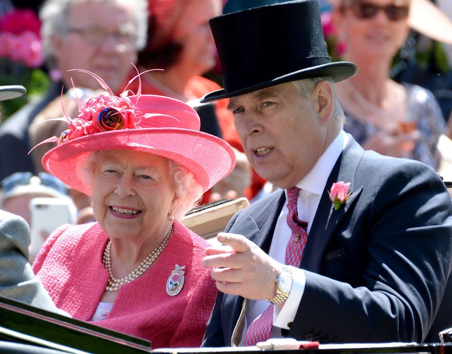 Queen Elizabeth in a pink hat and jacket, and Prince Andrew, in a top hat and suit, sit together in an open top carriage