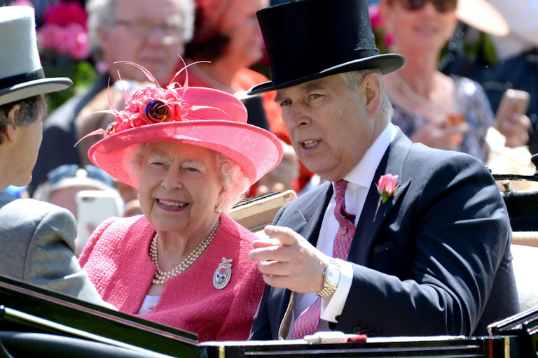 Queen Elizabeth in a pink hat and jacket, and Prince Andrew, in a top hat and suit, sit together in an open top carriage