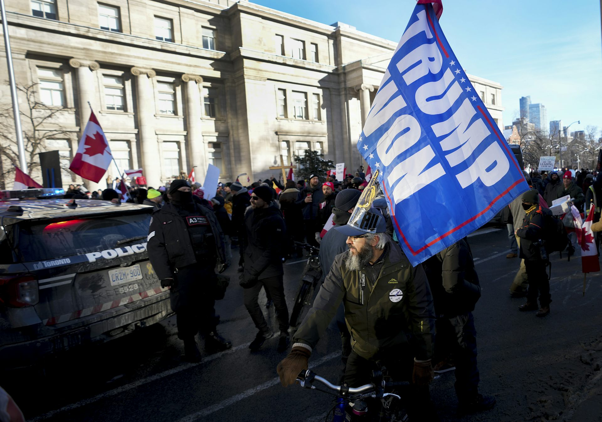 A man on a bicycle carries a flag that says 'Trump Won.'