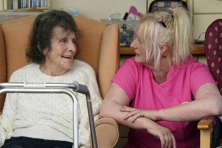 A carer and care home resident talking