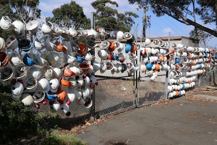 Hard hats on a gate