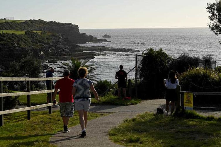 people walk towards beach