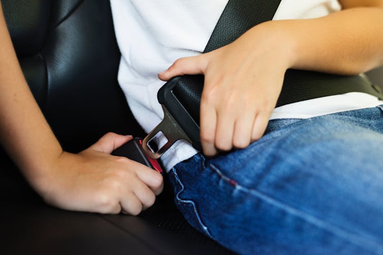 A person clipping in a seatbelt