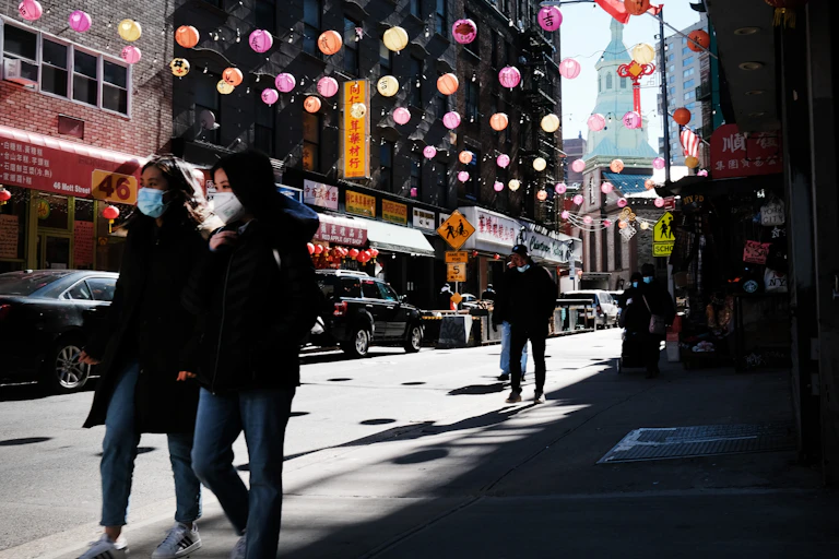 masked people walk in Chinatown