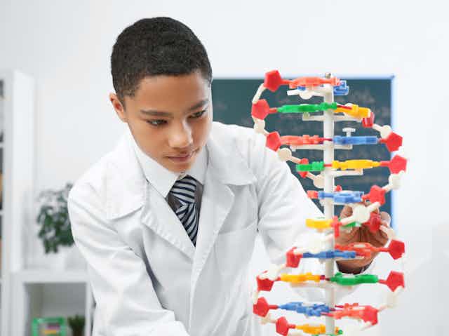 Boy looking at DNA model