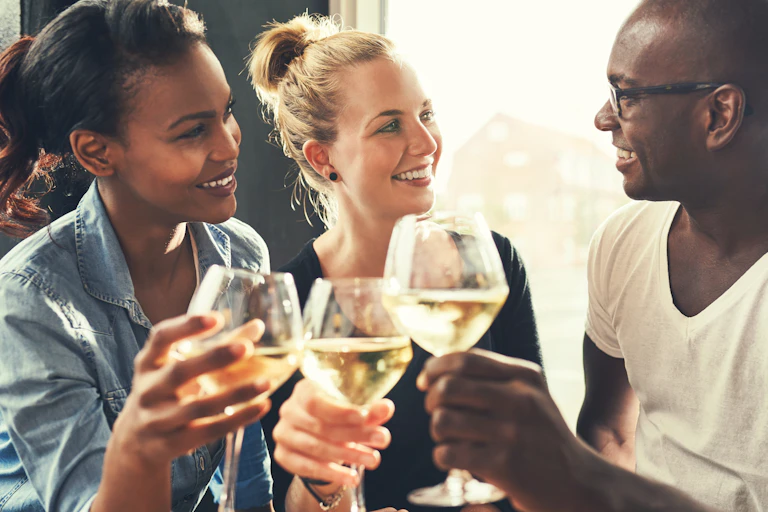 Three people with glasses of wine.