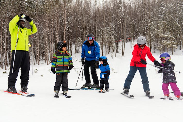 A family with young children on skis