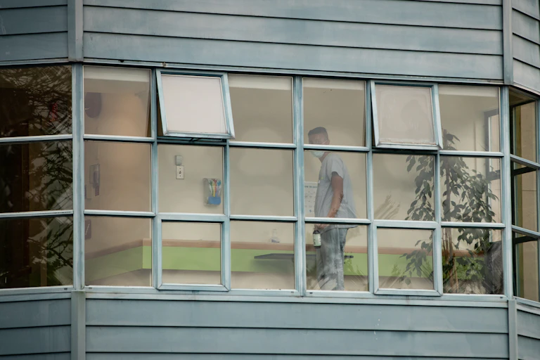 A person in scrubs seen through windows