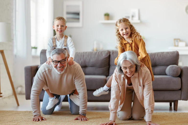 A family plays horse in a living room, two grandparents and two grandchildren
