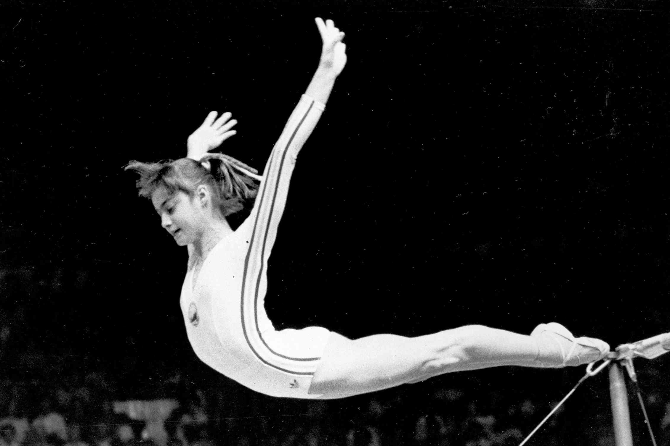 Nadia Comaneci dismounts from the uneven parallel bars to score a perfect