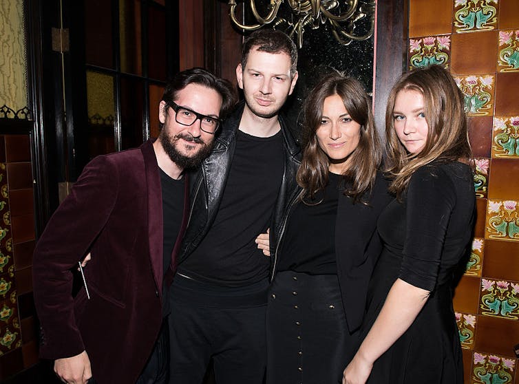 Two young men and two young women pose for a photograph.