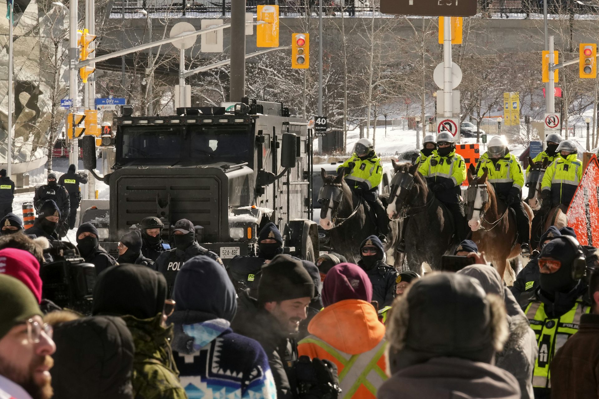 Protesters stand as police on horseback and tactical units approach