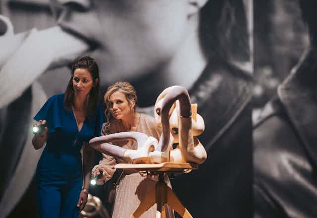 Two women with torches in an art gallery