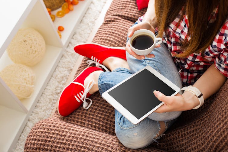 A woman rests her feet on the couch