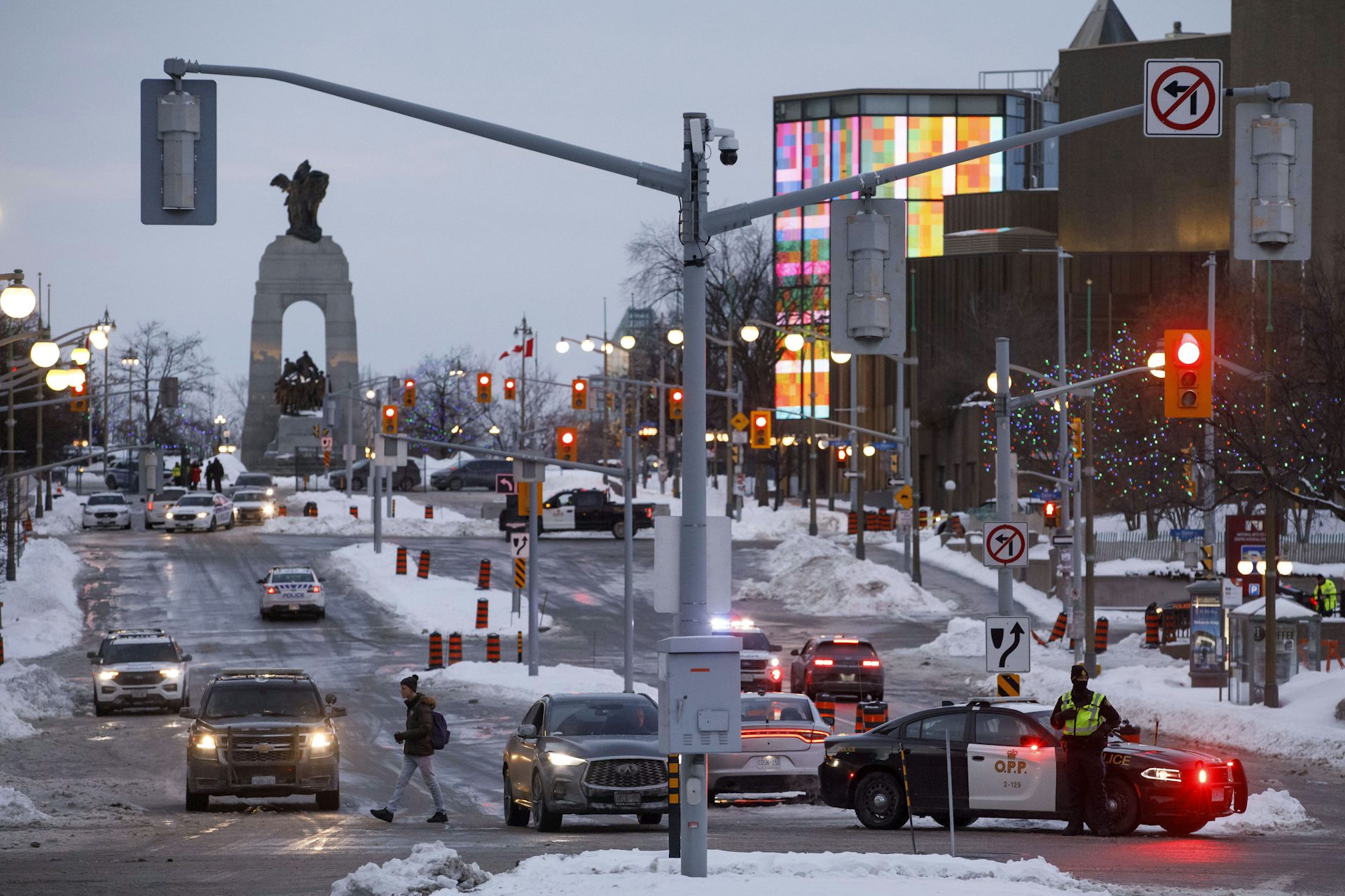 A police checkpoint is seen on a busy city street at dusk.