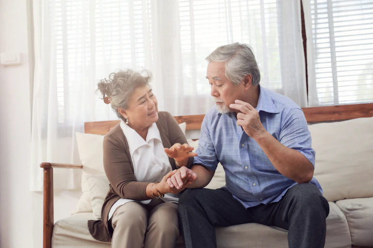 A senior woman and man sitting on a couch.