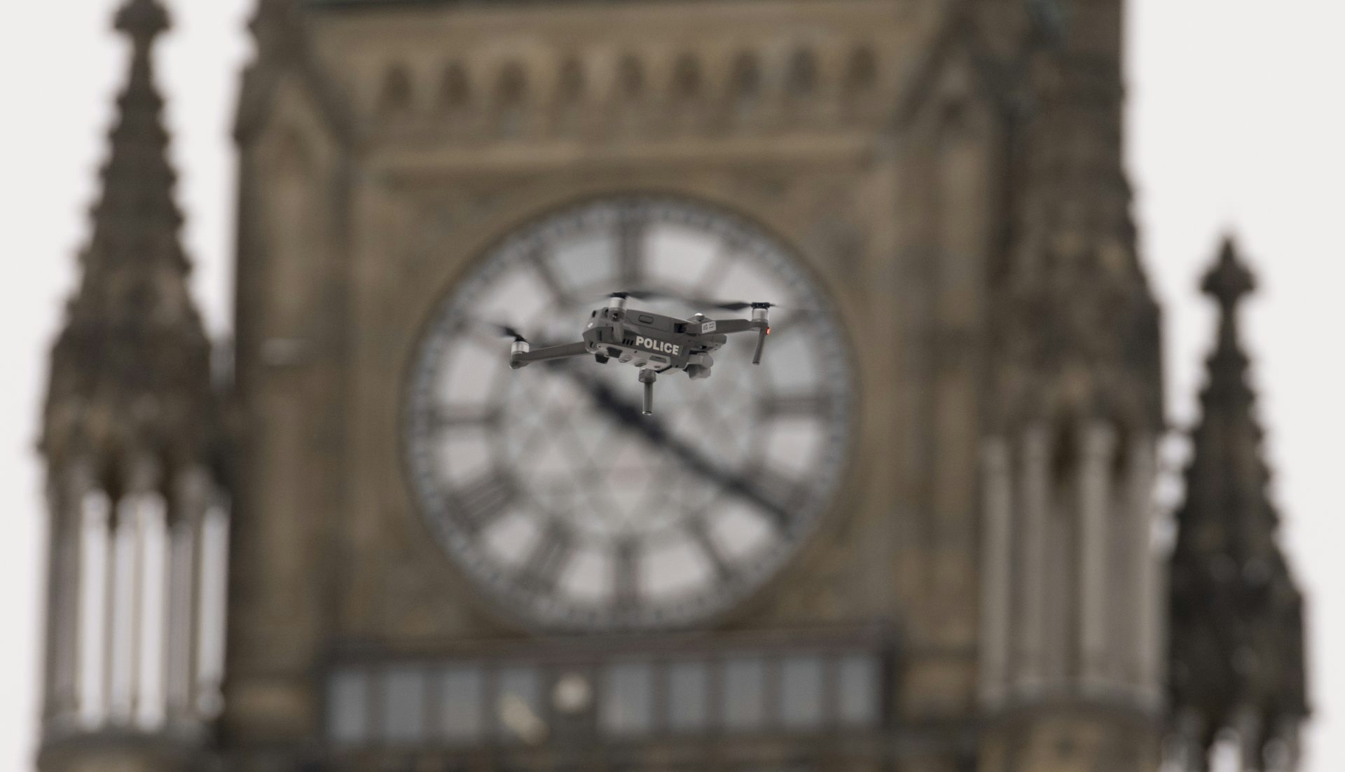A drone that says police hovers in front of the peace tower.