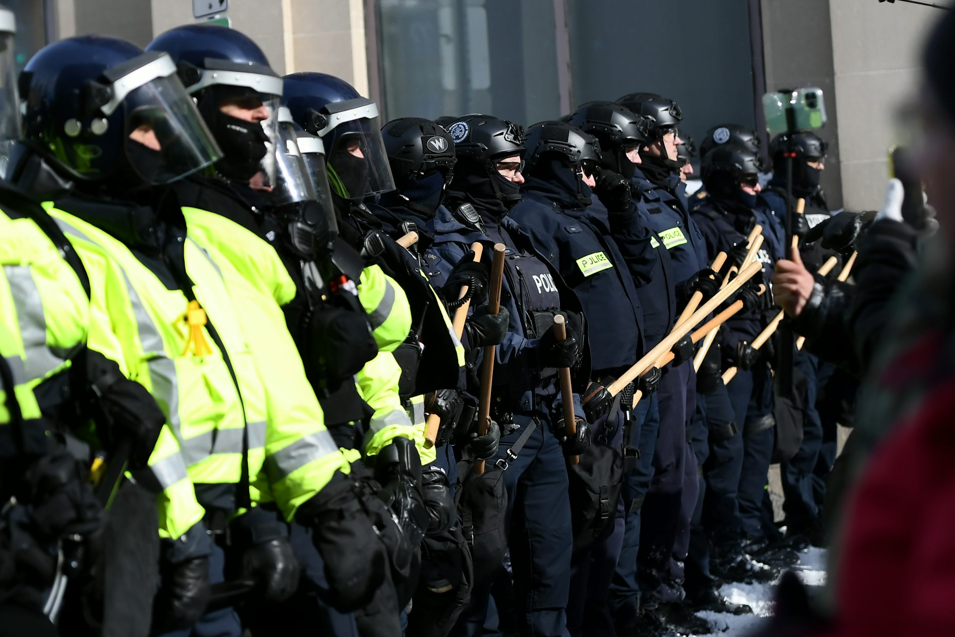 A line of armoured police, some holding batons.
