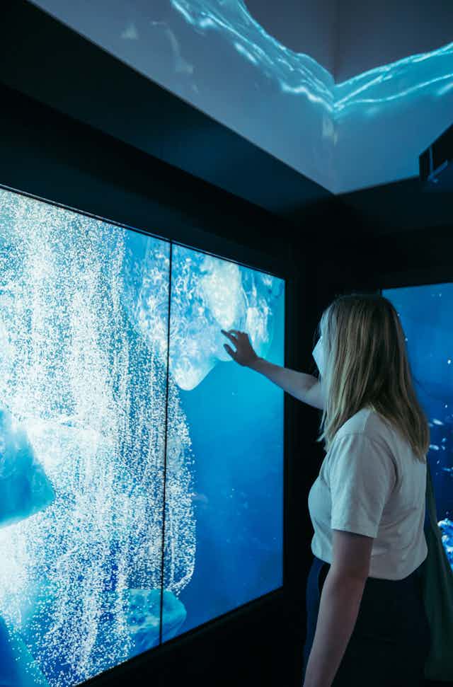A woman at a blue touch screen