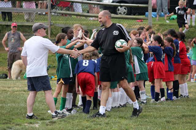 Teams, referee and coaches congratulating each other after a game