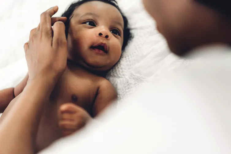 A ridiculously adorable baby looks at their mother