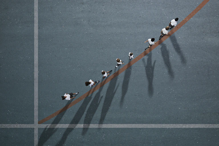 A bird's'-eye view of children in school uniform walking in a single file.