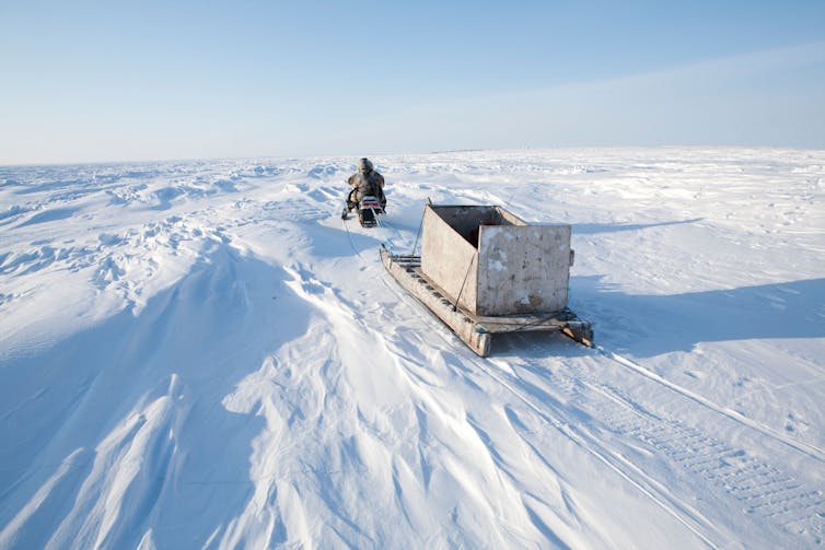 An Inuk on a snowmobile