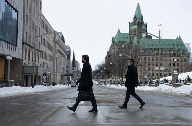Justin Trudeau and another government official cross the street
