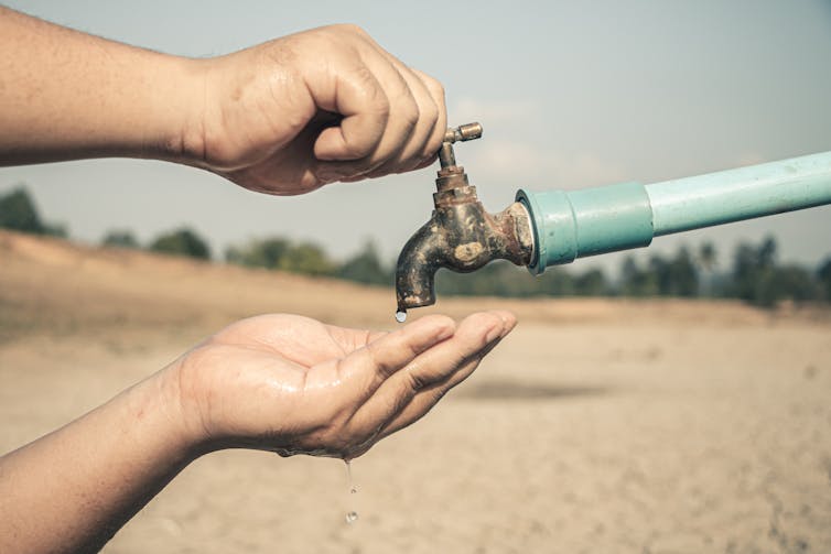 Hand under tap with no water coming out