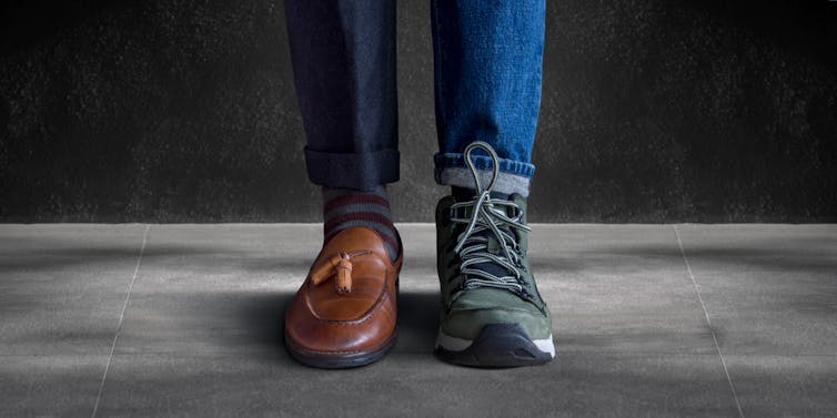A man's feet with a professional shoe on the right foot, and a casual sneaker on the left foot