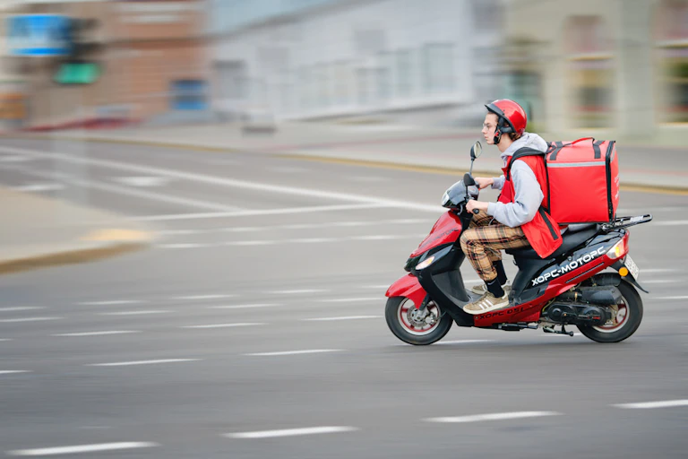 Food courier on a red scooter.
