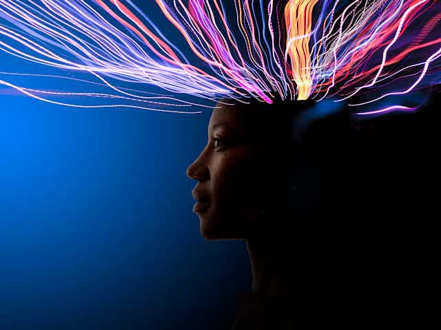 A person in profile with colored lines of energy coming from the top of the head