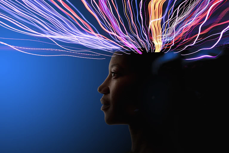 A person in profile with colored lines of energy coming from the top of the head