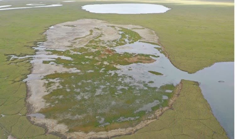 A landscape of lakes showing one losing its water.