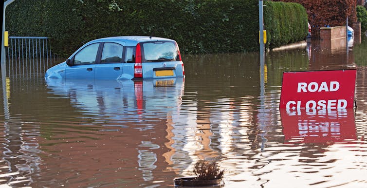 Blue car in flooded street