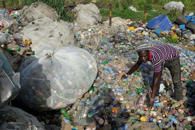 A man puts into bags plastic waste collected from various locations in Ibafo, Ogun State, southwest Nigeria.