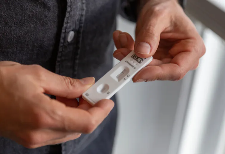 A man holding a lateral flow test