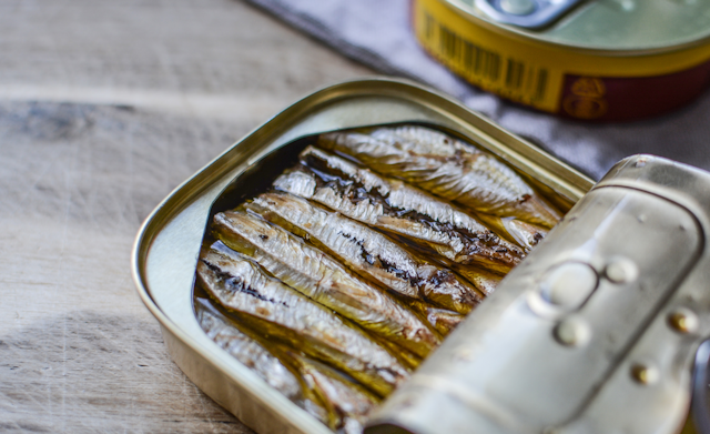 A half opened can of sardines in olive oil.