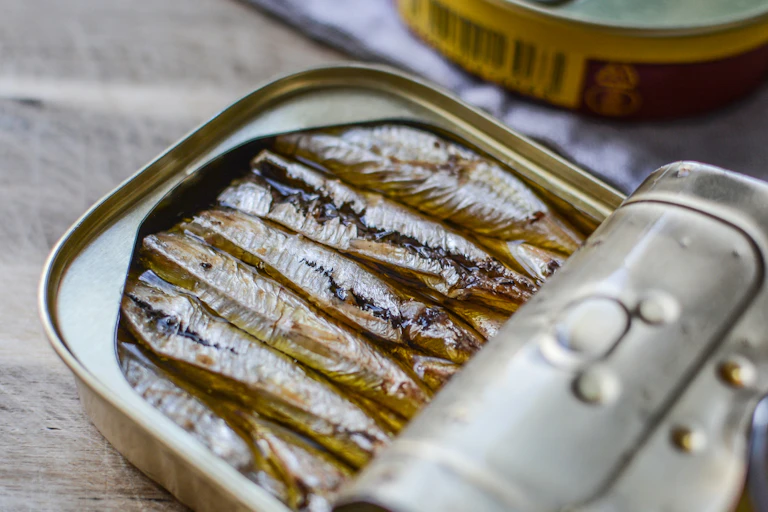 A half opened can of sardines in olive oil.