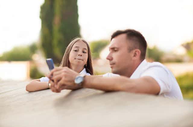 Father and daughter looking at smartphone