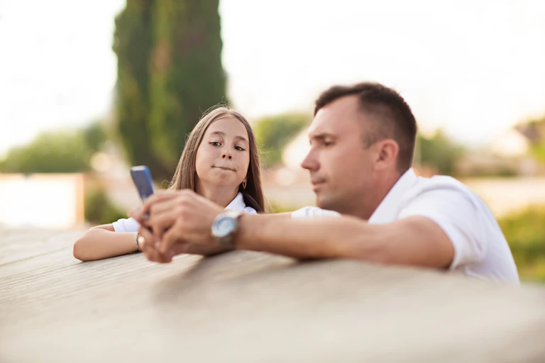 Father and daughter looking at smartphone