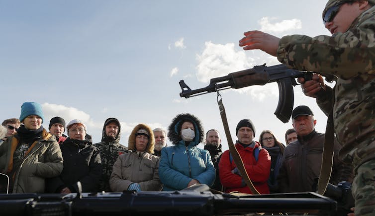 Un instructeur donne à des civils ukrainiens une formation de base sur les armes