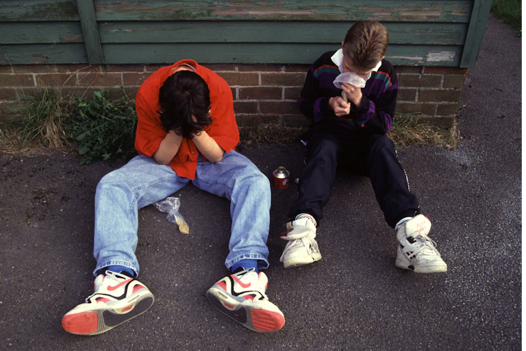 Two boys sniffing glue