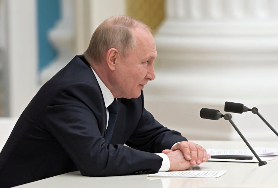 Vladimir Putin talking over a microphone at the Kremlin