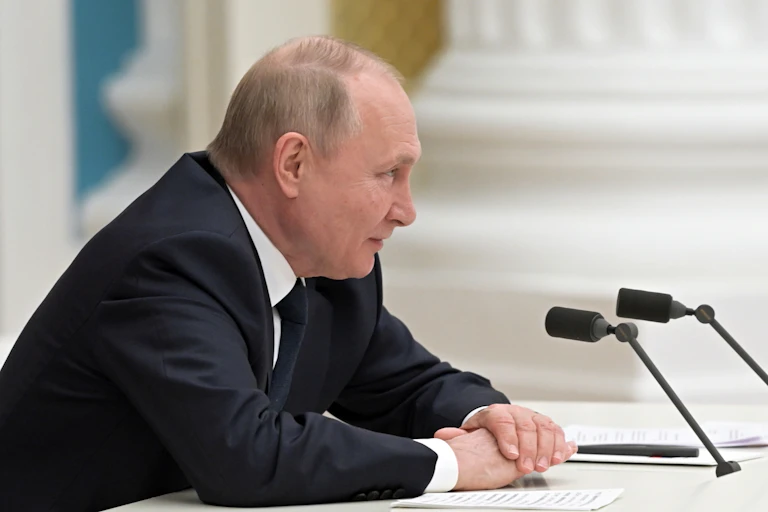 Vladimir Putin talking over a microphone at the Kremlin