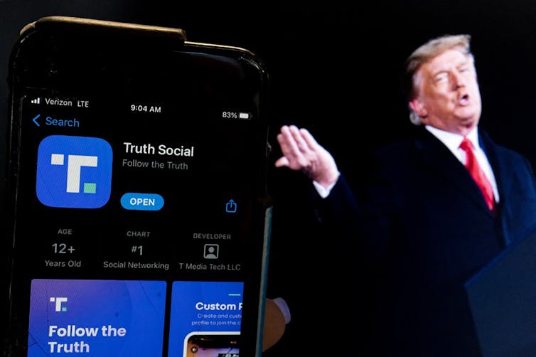 L’ancien président Donald Trump à côté d’un écran de téléphone qui affiche l’application « Truth Social » 