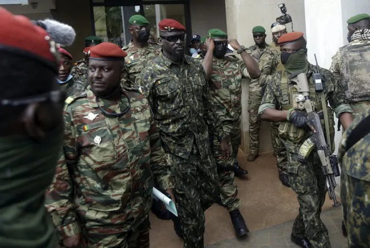 Des hommes vêtus d'habits militaires et armés