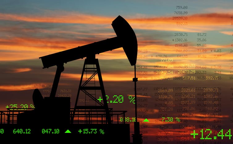 Silhouette of oil rig with market price figures in background.